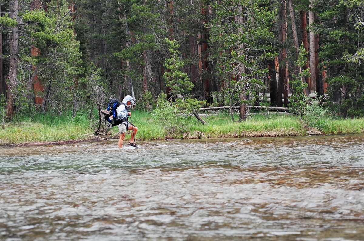 A fellow thru-hiker fording a wide stream.